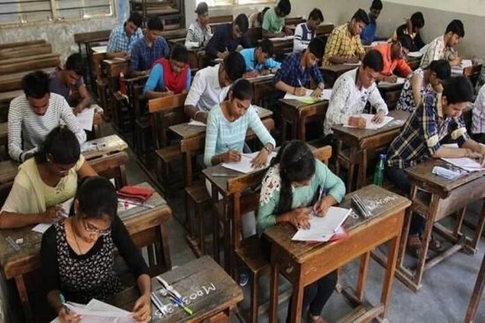 छात्र पढ़ाई करते हुए स्टडी मैटेरियल और नोट्स का उपयोग करते हुए