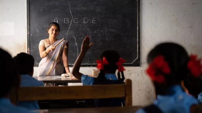 कक्षा में बच्चों को पढ़ाते शिक्षक का दृश्य